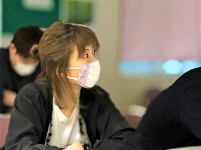 女性職員がスライドを見ながら講師の説明を聞いている 女性職員がスライドを見ながら講師の説明を聞いている